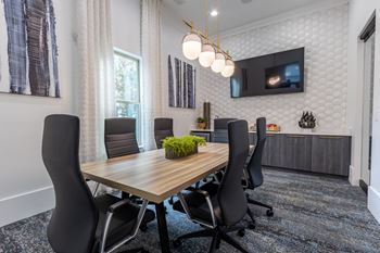 a conference room with a wooden table and chairs and a television